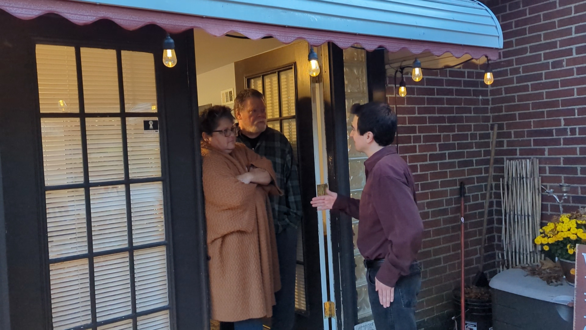 Candidate for State Representative, Nathan Jarosz, has discussion at a door of members of the community.